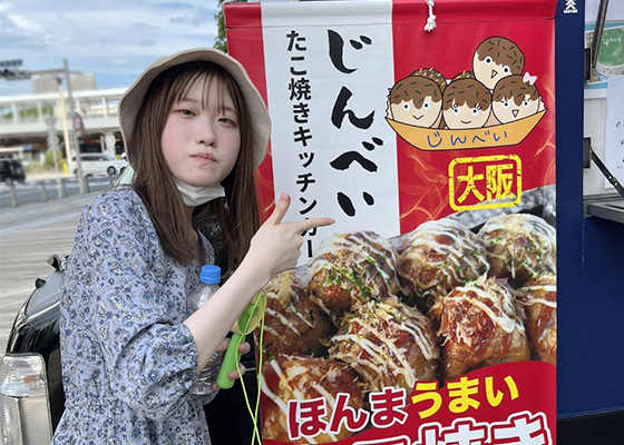 たこやきキッチンカーじんべいのタペストリーを指さしている写真